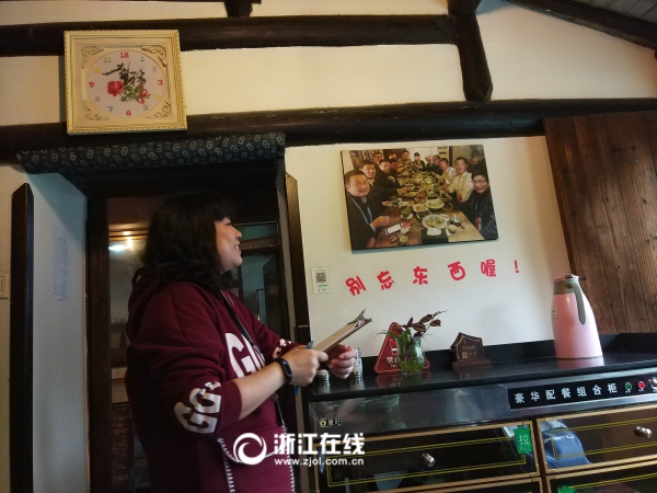 民宿老板娘站在2015年的大咖合影旁，對每位大咖的身份都如數(shù)家珍。.jpg