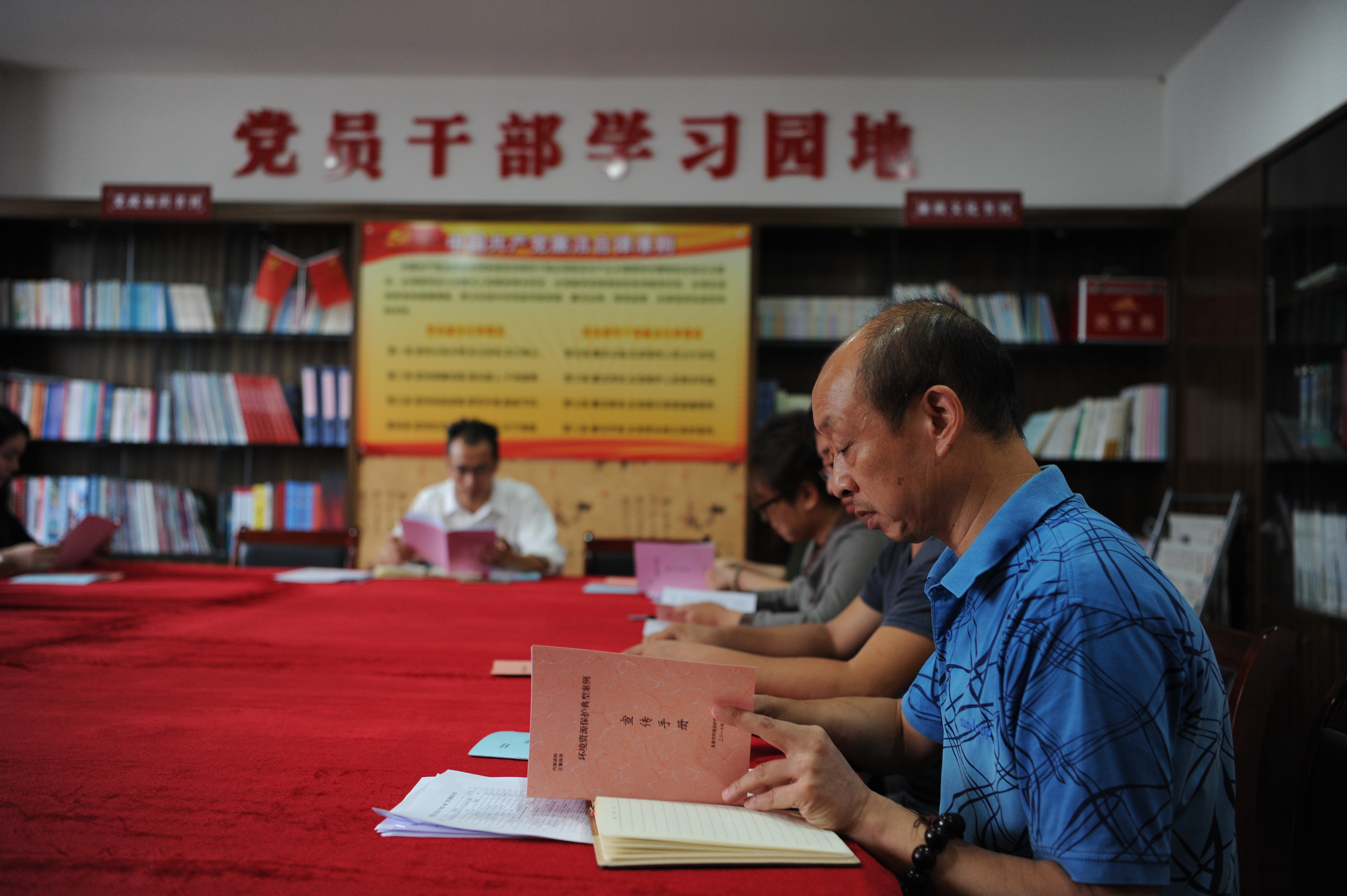 圖為環(huán)保局黨員干部在黨員活動室學(xué)習(xí)《環(huán)保資源保護(hù)典型案例》.JPG