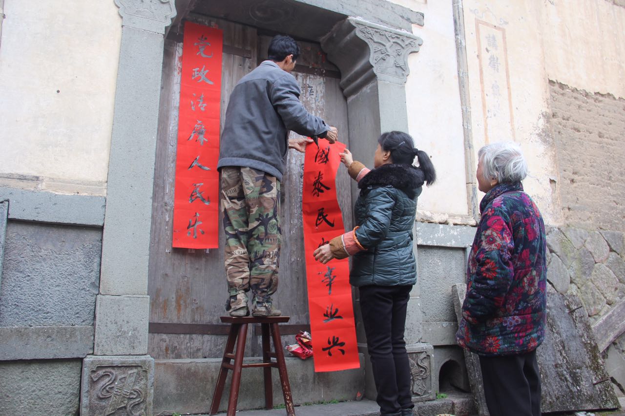 圖為毛垟鄉(xiāng)毛垟村的村民將得到的“廉潔春聯(lián)”貼在自家大門上，讓該村的春節(jié)有了濃濃的“廉”味.jpg