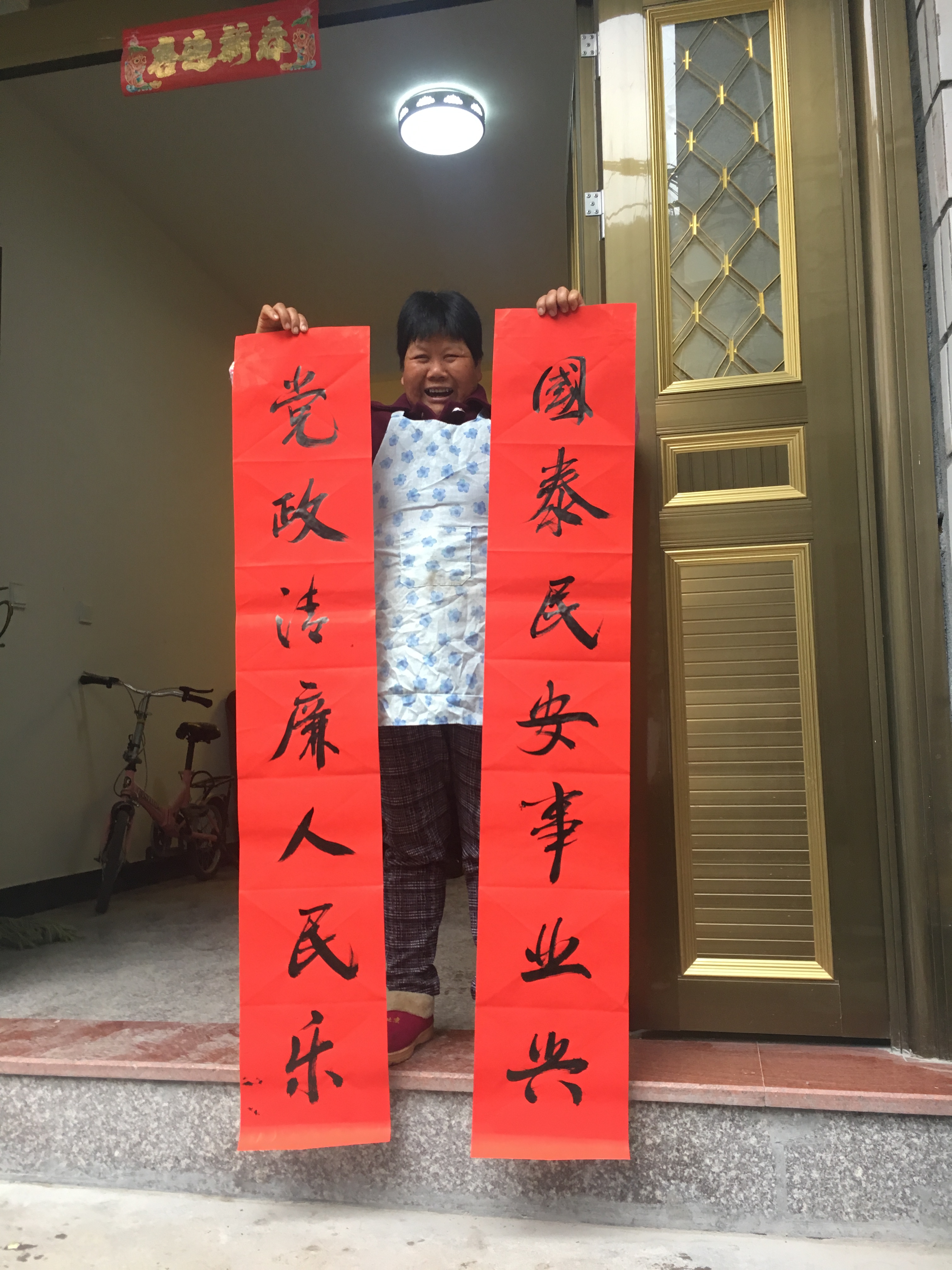 圖為毛垟鄉(xiāng)毛垟村的村民正喜滋滋地將剛得到的“廉潔春聯(lián)”拿回家張貼，讓該村的春節(jié)有了濃濃的“廉”味.jpg